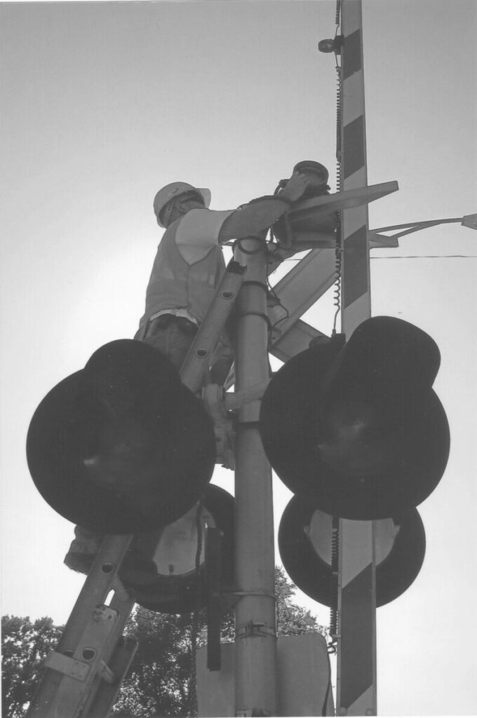 Signal Maintainer James "Jimmy" Hansen replacing a bell at 103rd Street Crossing.